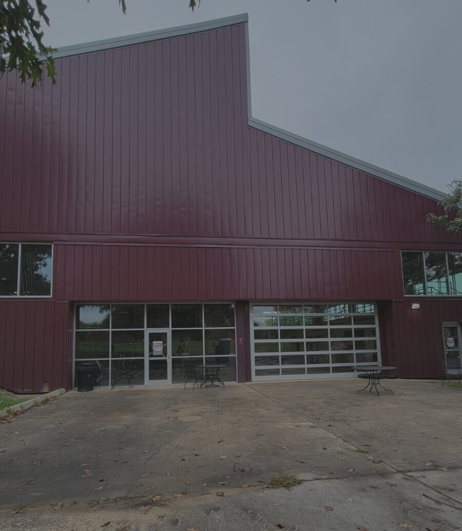 Large maroon metal building with patio tables outside