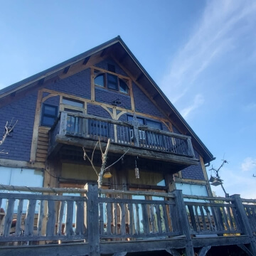 Wooden house with a balcony and blue sky background