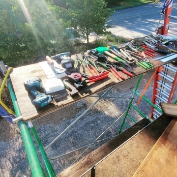 Various tools arranged on a workbench outdoors