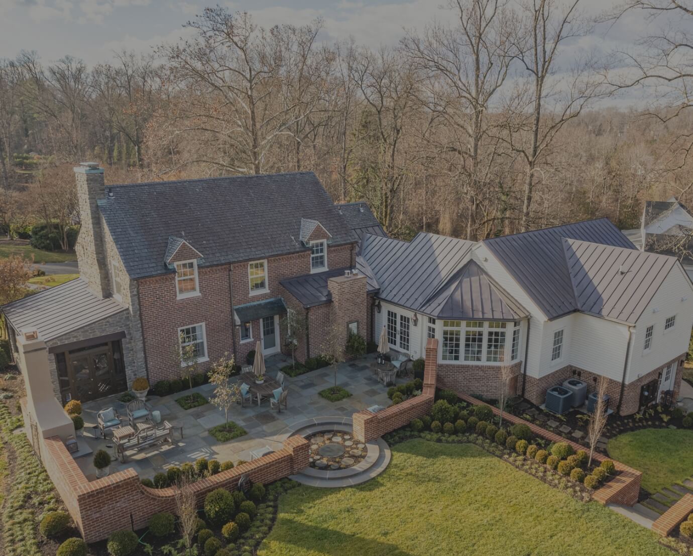 Large house with brick and stone, patio, and landscaped yard